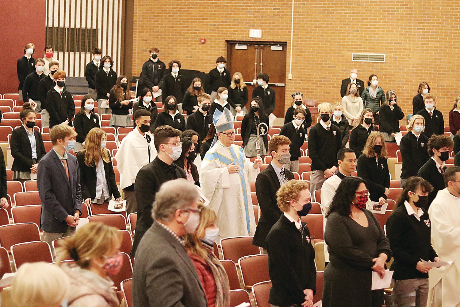 Bishop Thomas J. Tobin processes into a socially distanced Prout School auditorium to celebrate Mass on the Feast of the Immaculate Conception.